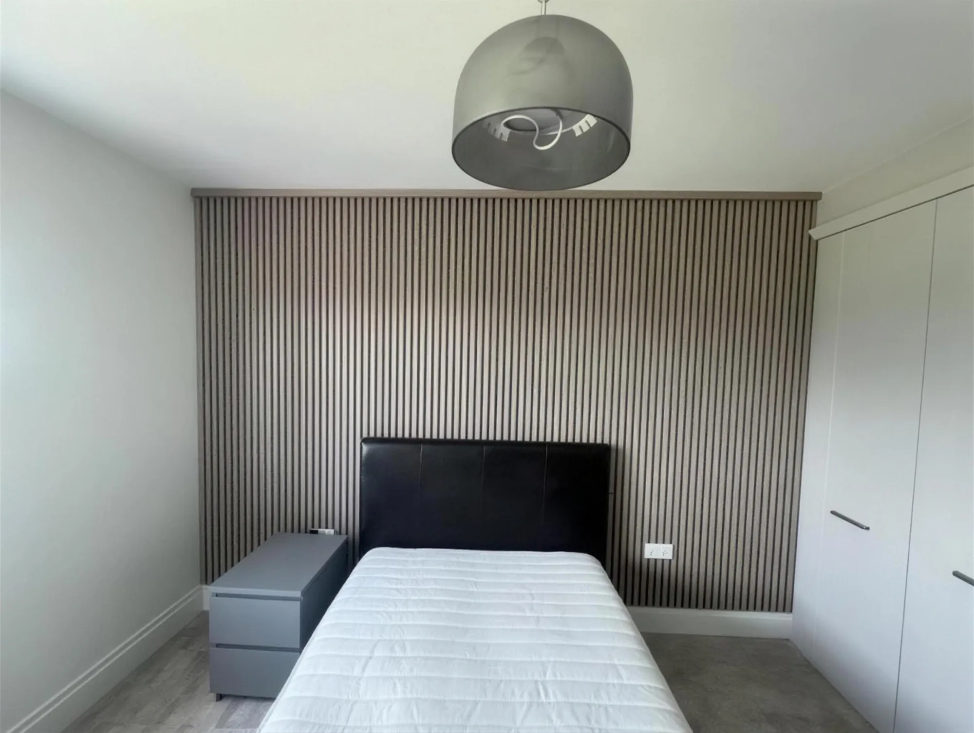 Bedroom with slatted wood panelled feature wall