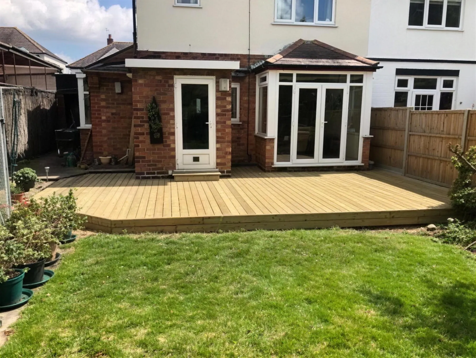 New softwood decking across the full width of a rear garden
